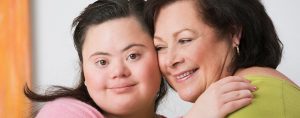 youth girl with down syndrome hugging mom